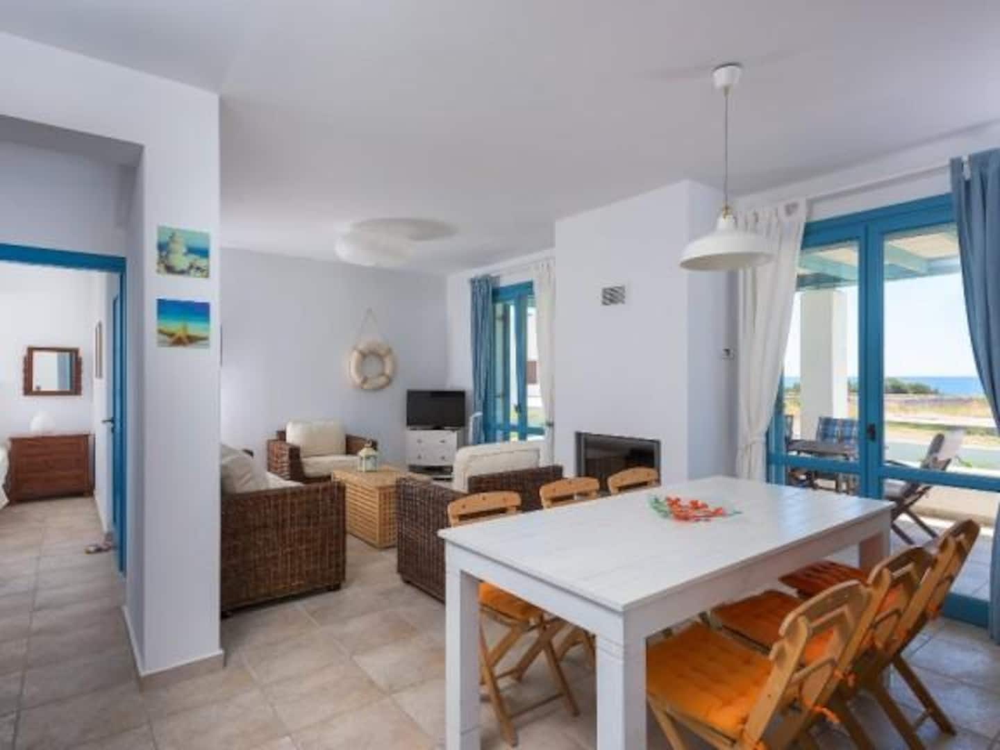 Dining table and living room with sea view at Villa Ilios